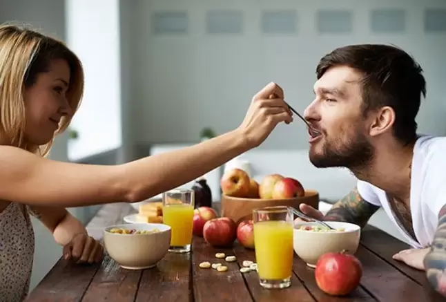 a woman feeds a man nuts to increase strength
